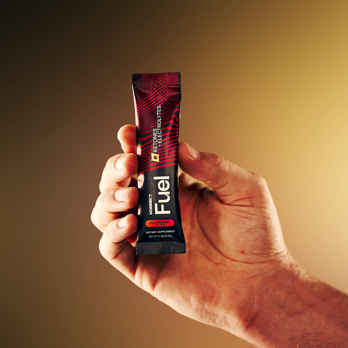 A hand holding a Korrect Fuel stick packet